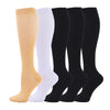 A row of medical grade compression socks in shades of beige, white, and black.