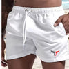 White quick-drying men's swim shorts being held by a hand
