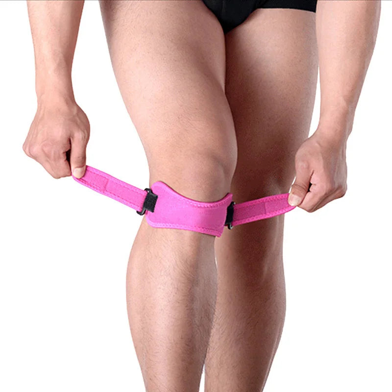A person is wearing a pink adjustable patella tendon support brace on their knee.