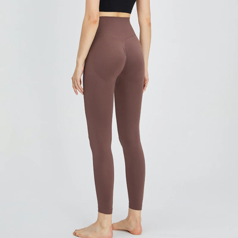A model wearing high-waist seamless yoga leggings in a dusty rose color.