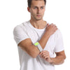 A man wearing a white t-shirt is shown with an adjustable tennis elbow brace on his forearm.