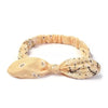 A beige fabric elastic hair headband with a subtle black floral paisley print.