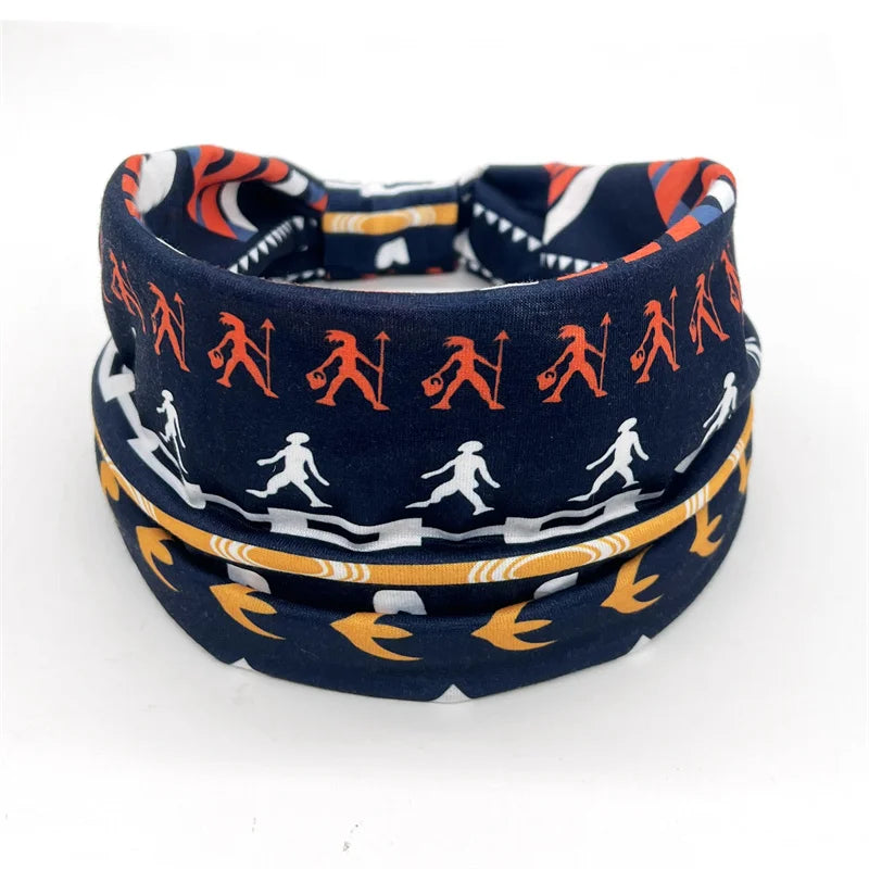 A navy blue bohemian stretch cotton headband featuring orange and white tribal-inspired patterns.