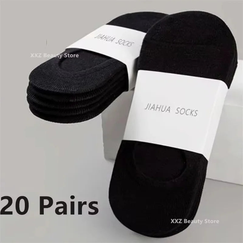 A pair of black invisible silicone no-show boat socks with a white label shown on a white background.