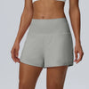 Eine Frau trägt hellgraue, schnelltrocknende Sportshorts für Damen.