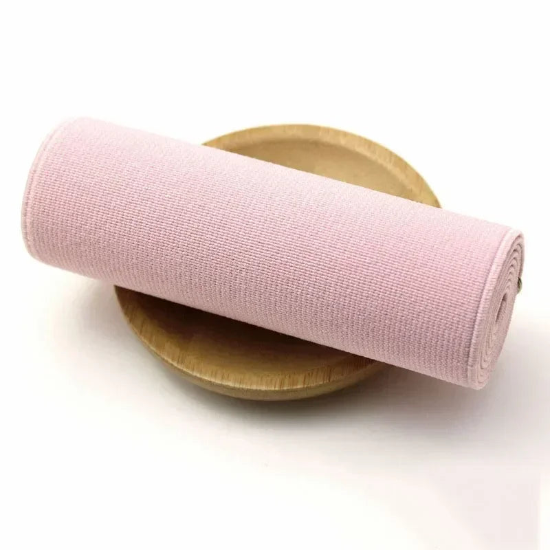 Pink elastic band rolled up on a wooden surface