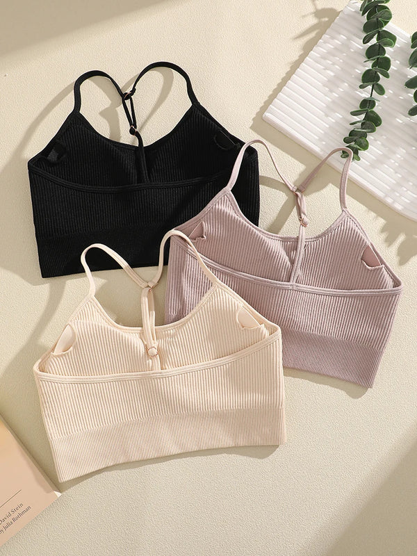 Three women's ribbed crop tops in black, lilac, and cream are displayed against a light background.