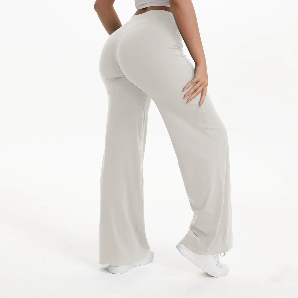 A person is modeling light beige NCLAGEN SoftMotion straight leg yoga pants.