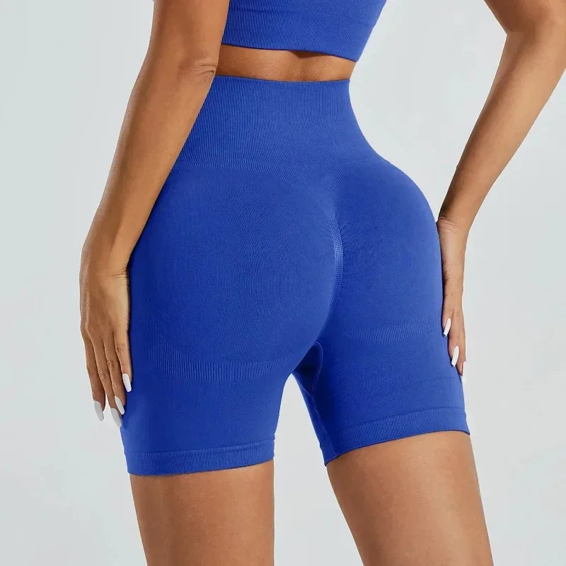 A woman wearing royal blue high-waisted yoga shorts.
