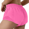 Pink women's high-waisted running shorts worn by a model.