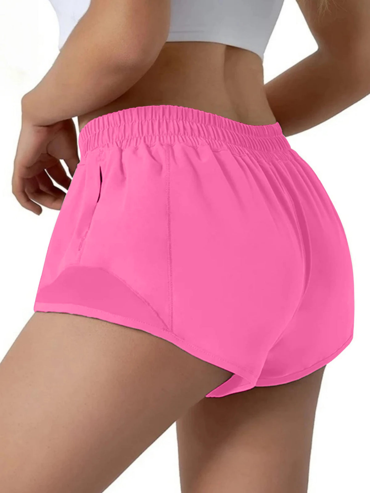 Pink women's high-waisted running shorts worn by a model.