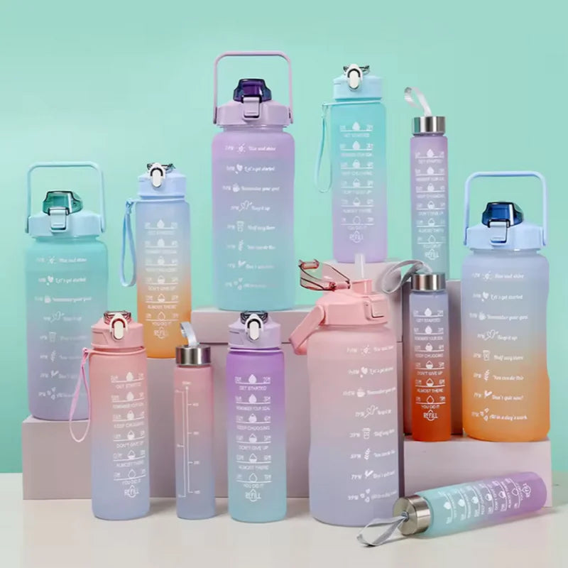A collection of various leakproof sports water bottles in shades of purple, pink, and teal with straws.