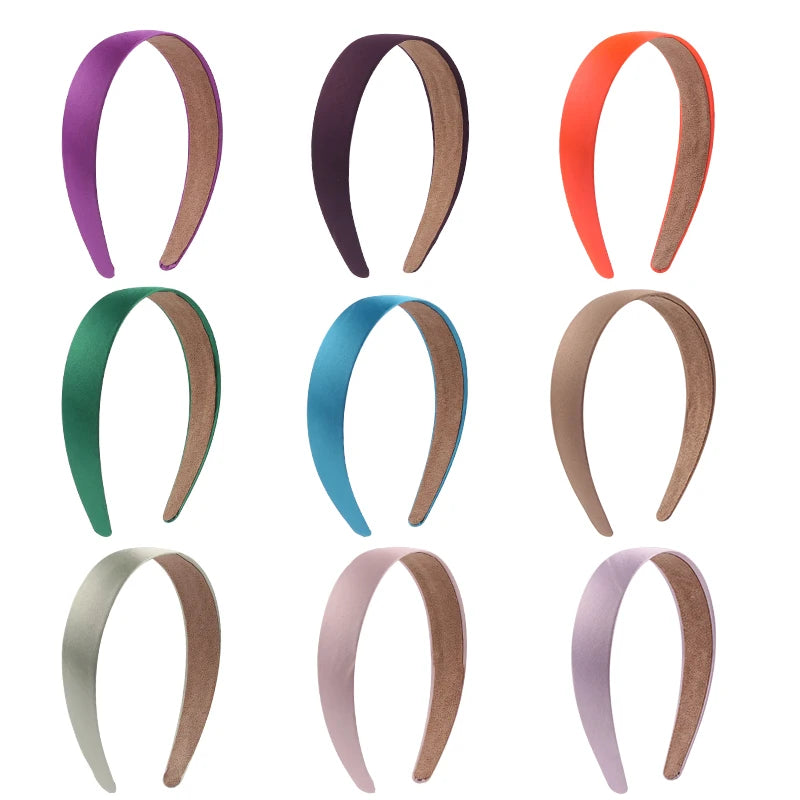 A collection of solid satin hair bands in various colors including purple, dark brown, orange, teal, beige, and pink.