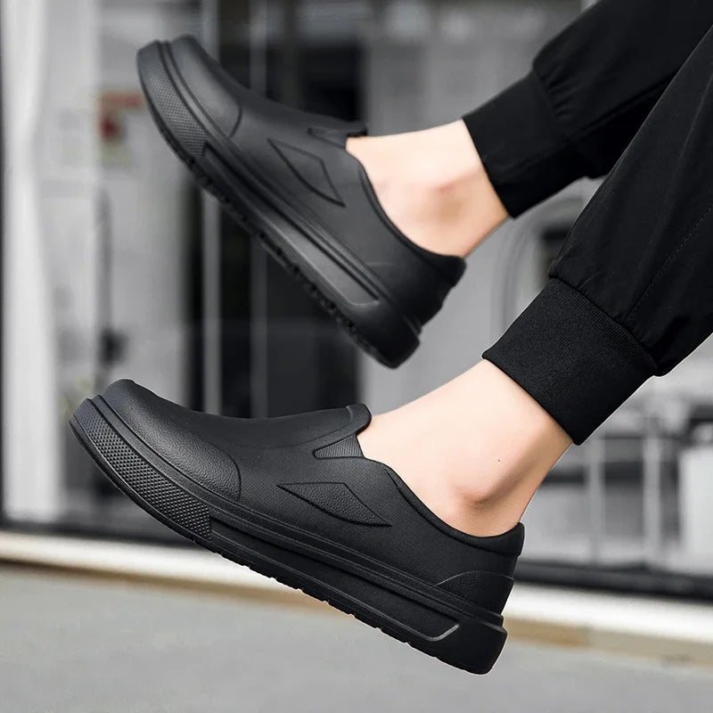 A pair of black men's anti-slip oil-resistant kitchen clogs shown from the side.