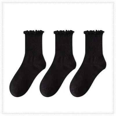 A set of three black cotton ruffle ankle socks displayed against a white background.