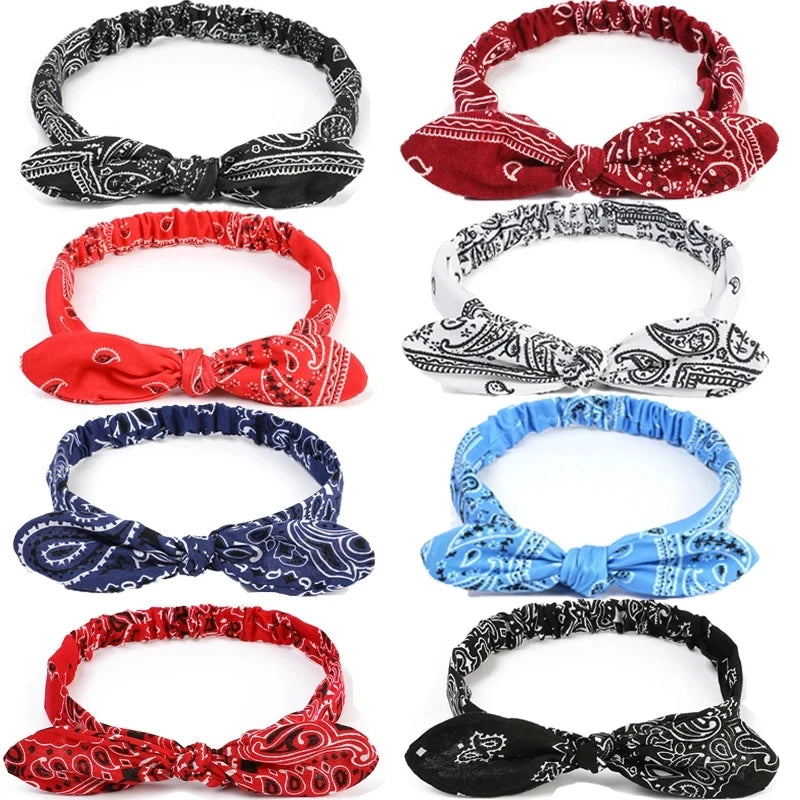 A collection of eight elastic hair headbands featuring various paisley patterns in red, black, white, and blue.