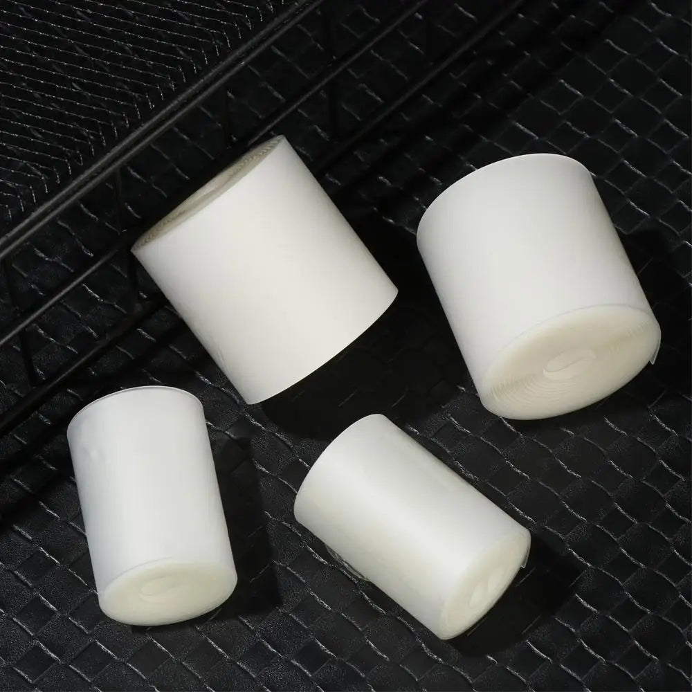 Cuatro rollos de liner para neumáticos de bicicleta blanca mostrados sobre una superficie oscura.