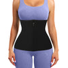 A woman wearing a black body shaping waist trainer corset over a light purple top and matching pants.