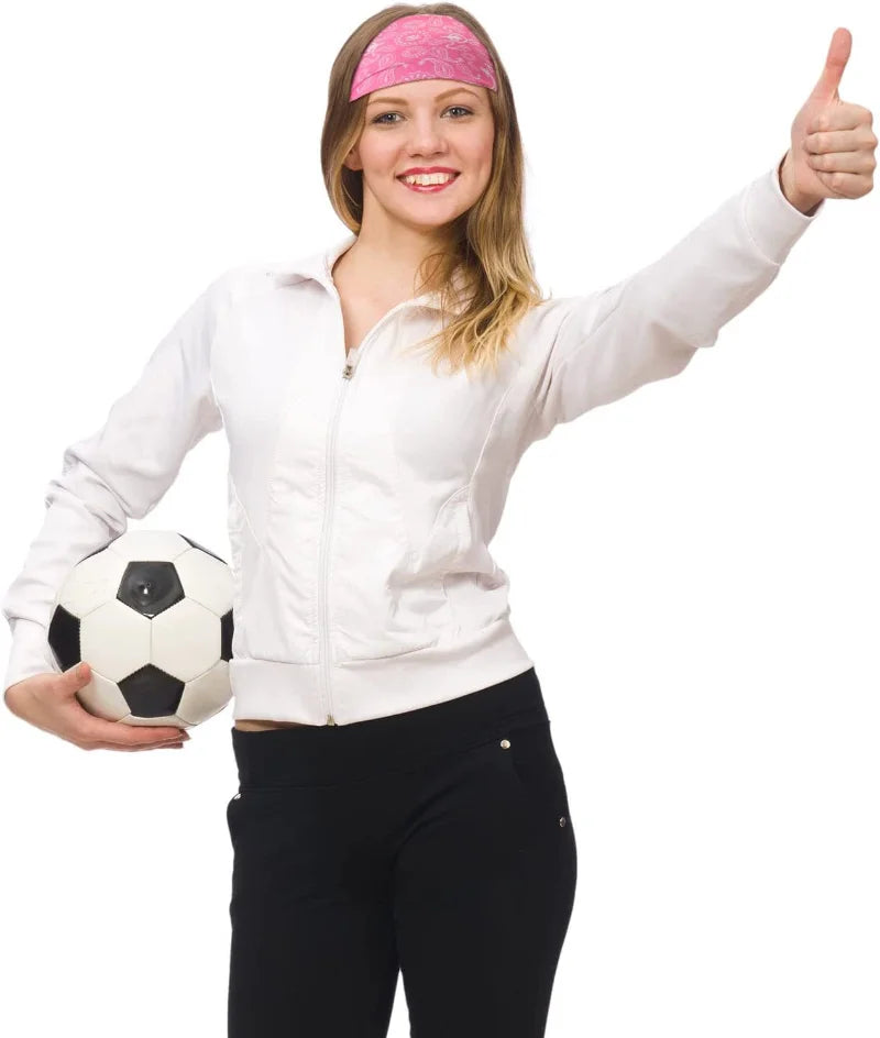 A smiling woman wearing a pink sports headband and a white jacket, holding a soccer ball.