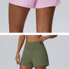 Eine Frau modelliert rosa und olivgrüne schnelltrocknende Sportshorts.