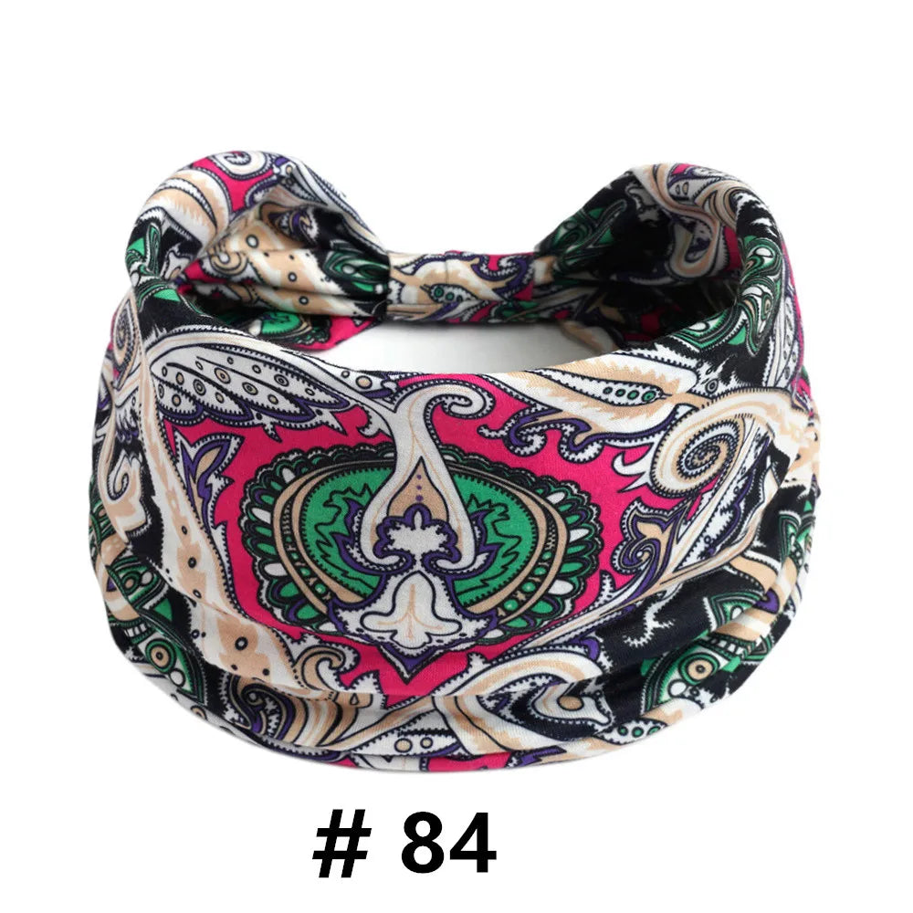 A close-up of a boho print cotton headband featuring pink, green, and beige patterns.