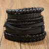 Stapel dunkle braune Lederblattrassel-Armbänder auf Holzoberfläche