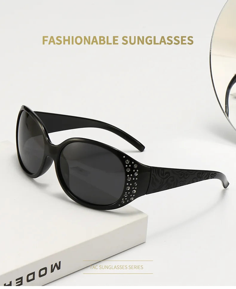 Black fashionable sunglasses with diamond-inlaid detailing displayed on a white surface.