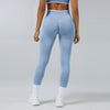 A person wearing light blue high-waist yoga leggings and a matching sports bra top.