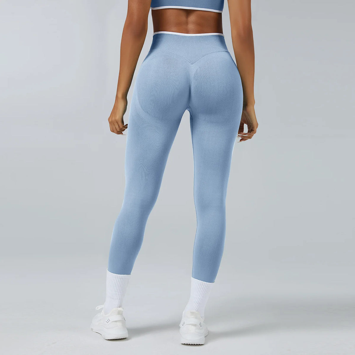 A person wearing light blue high-waist yoga leggings and a matching sports bra top.