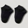Una pila de calcetines de algodón unisex negros y transpirables, vistos desde el lado.