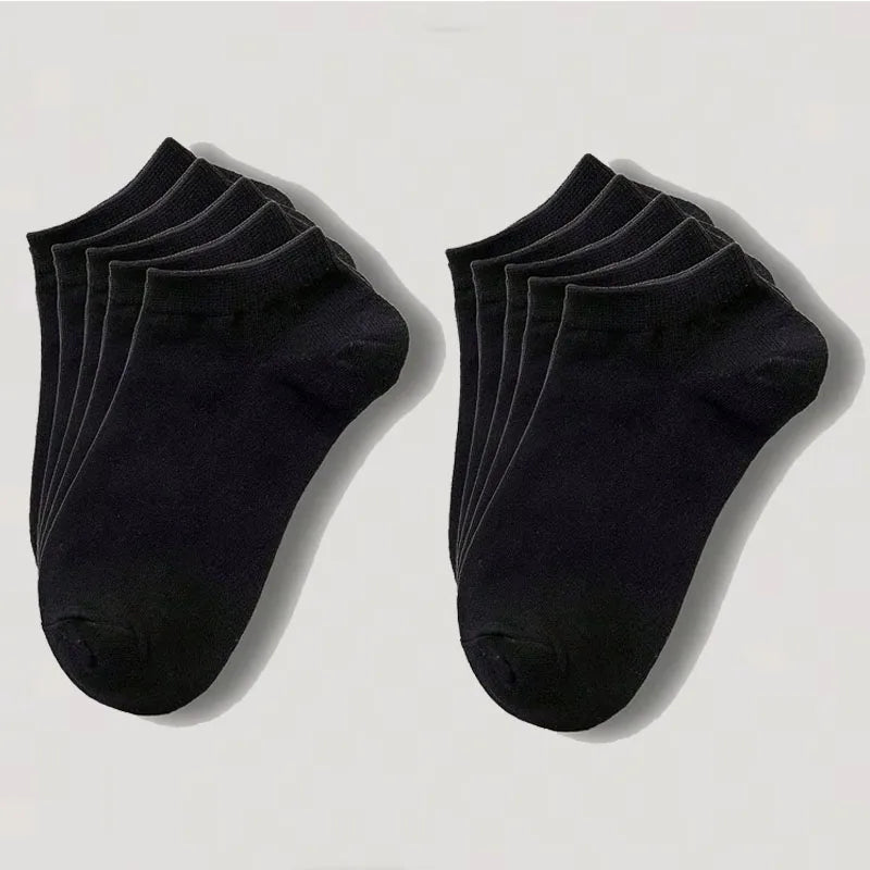 Una pila de calcetines de algodón unisex negros y transpirables, vistos desde el lado.