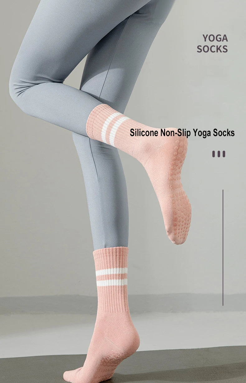 Un par de calcetines de yoga de silicona rosa antideslizantes puestos en el pie y tobillo de una persona.