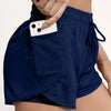 Navy blue athletic shorts with mesh pockets being held by a hand