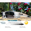 A pair of clear photochromic lenses worn in a futuristic frame against a natural outdoor background.