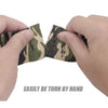 Hands tearing apart a piece of camouflage elastic wrap tape to demonstrate its strength.