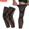 A pair of black copper ion infused knee compression sleeves being worn on a person's leg.