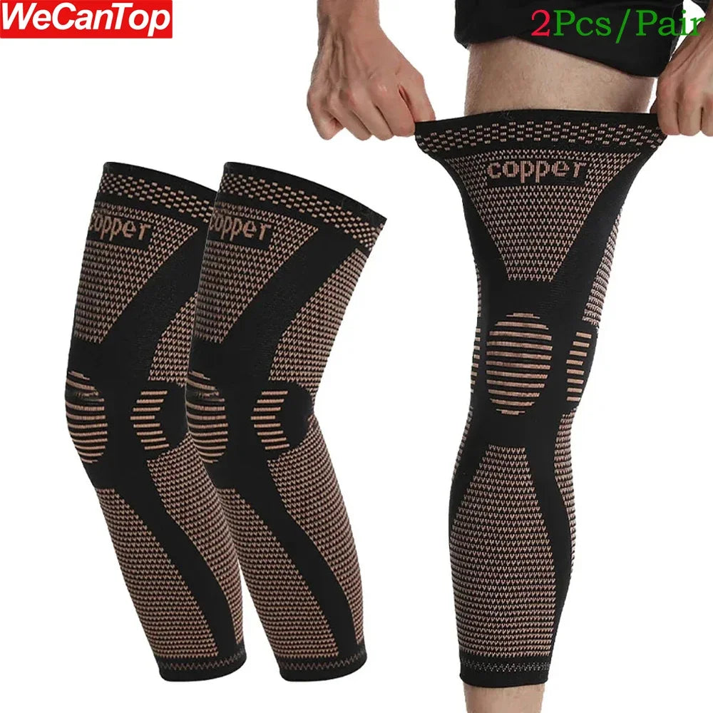 A pair of black copper ion infused knee compression sleeves being worn on a person's leg.