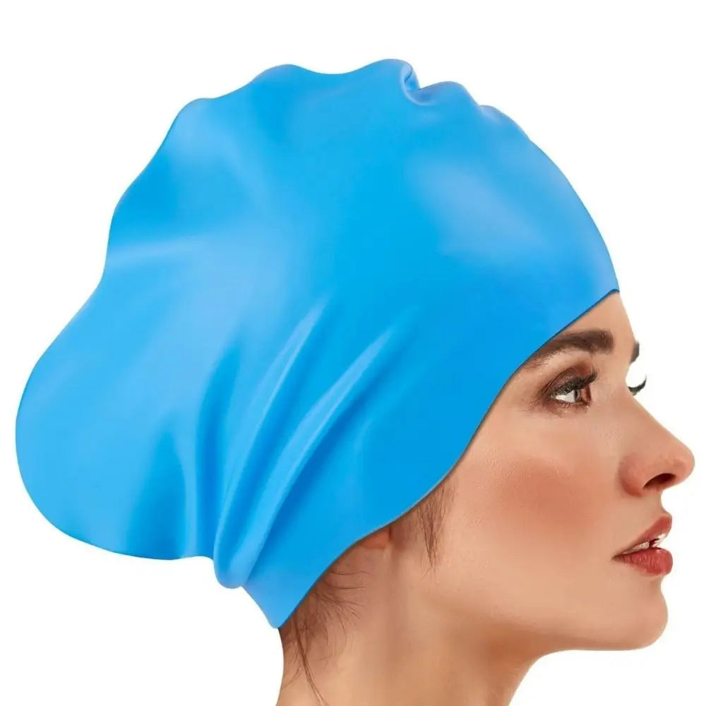 A close-up of a bright blue silicone swim cap being worn on a woman's head.