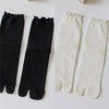 Pair of black and white knit crew socks with ruffle cuffs