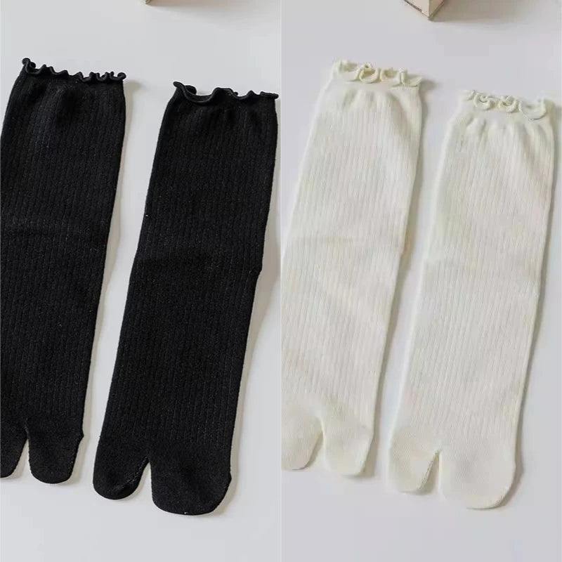 Pair of black and white knit crew socks with ruffle cuffs