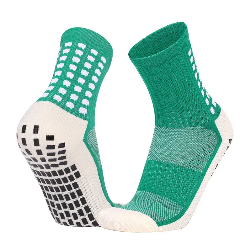 A pair of green and white performance sports grip socks shown from the side.