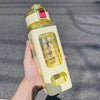 A hand holds a clear, leakproof sport water bottle with yellow and white accents against a gray background.