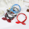 A collection of boho paisley elastic hair headbands in blue, black, and red are displayed on a white surface.