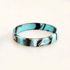 A black and teal marbled silicone wristband with the number 8 engraved on the front.