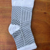 White and black therapeutic compression socks for foot and ankle pain relief