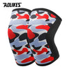 A pair of black knee sleeves featuring a camouflage pattern with red, blue, and gray shapes.