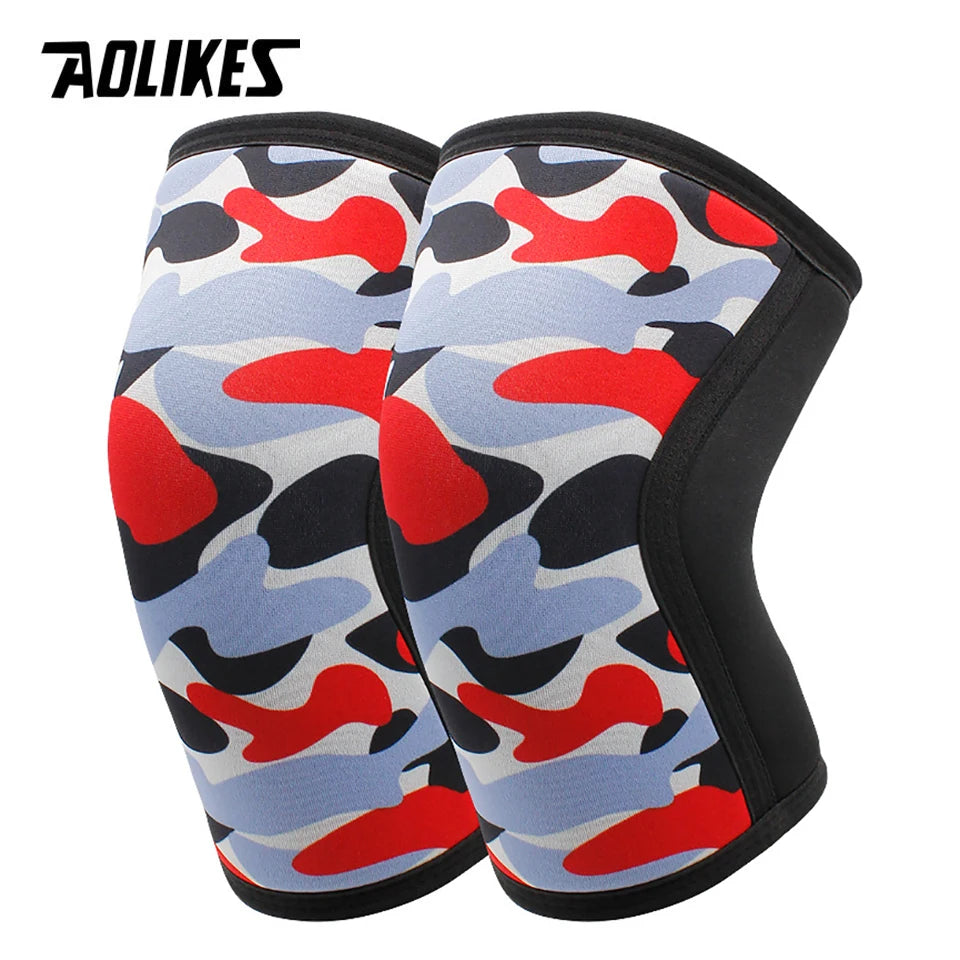 A pair of black knee sleeves featuring a camouflage pattern with red, blue, and gray shapes.