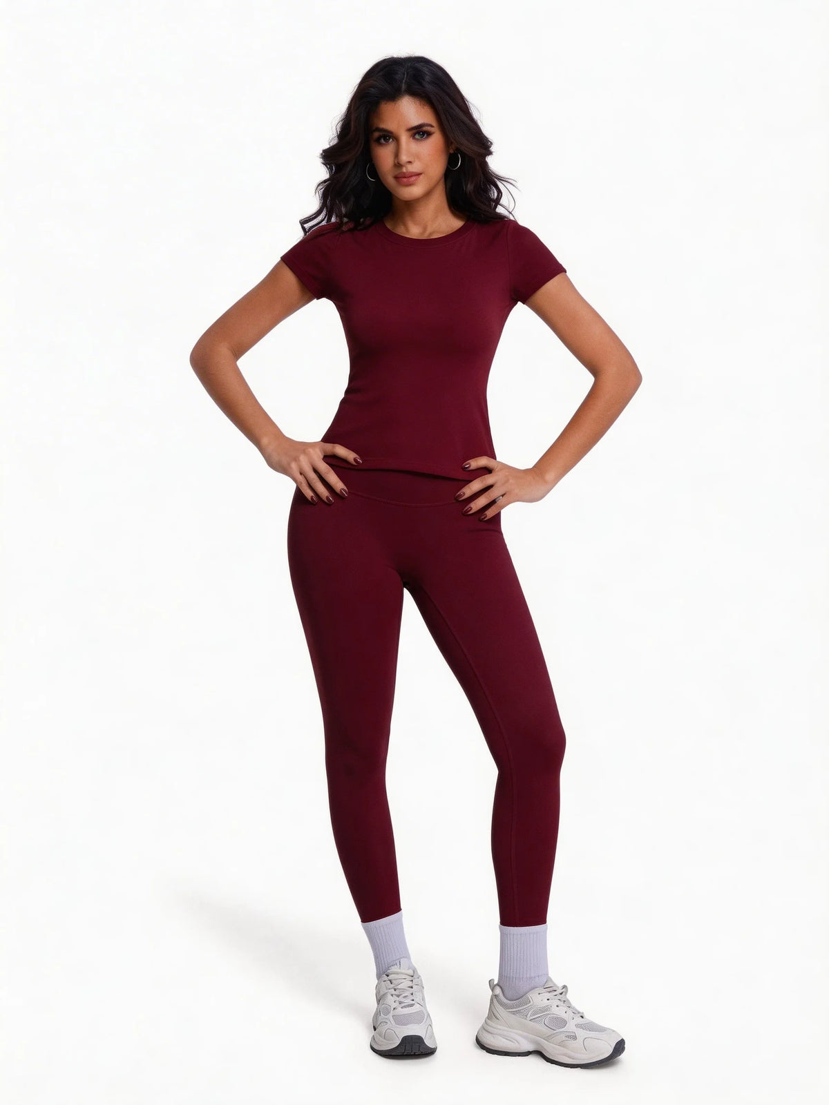 Una mujer modela un conjunto de yoga sin costuras de cintura alta en color borgoña intenso.