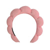 A pink microfiber skincare headband and wristband set.