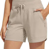 Light beige high-waisted quick-dry athletic shorts worn by a woman.